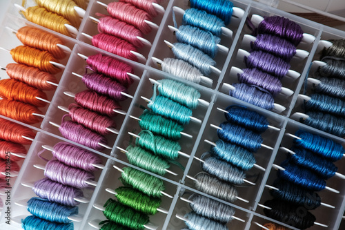 Close up of colorful embroidery floss bobbins in the box. Embroidery threads for handmade, crafts, hobbies.