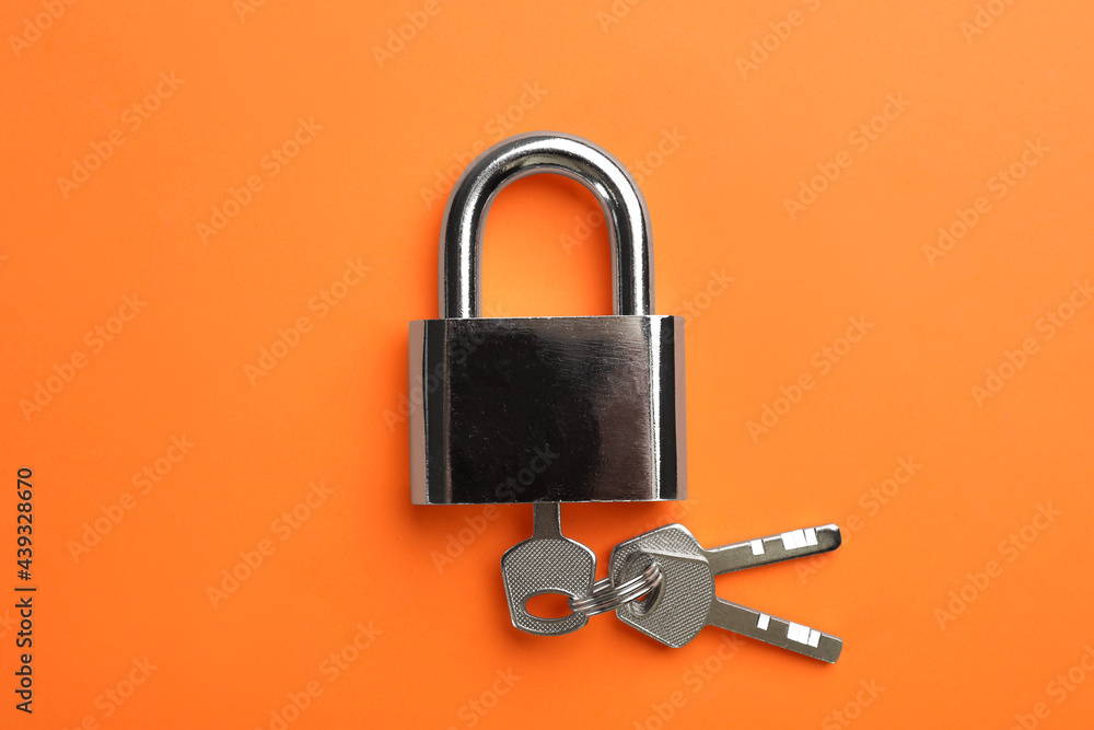 Modern padlock with keys on orange background, top view - obrazy, fototapety, plakaty 