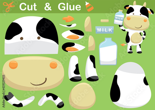 Funny cow cartoon standing while holding bottle milk. Education paper game for children. Cutout and gluing