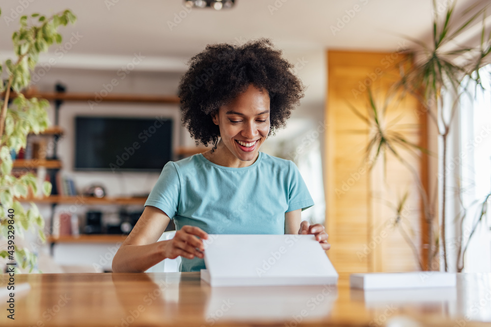 Adult African woman, looking at her birthday present. Adult African woman, looking at her birthday present.