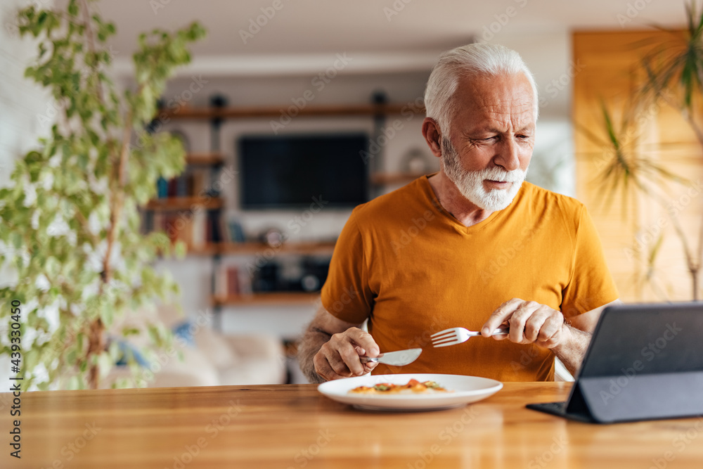 Mature man, watching a movie and eating. Mature man, watching a movie and eating.