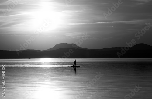 a young man doing paddleboarding on the lake