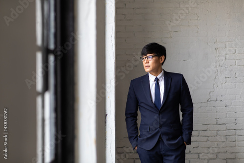 Portrait of successful business people woking in office. Handsome asian business man standing at home office. © NVB Stocker