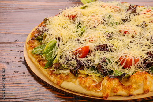 Pizza caesar with chicken, salad and cheese
