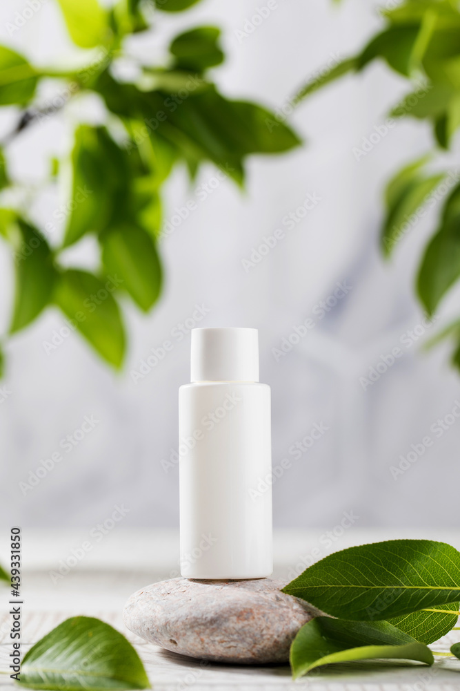 A white tube of cosmetics on a stone among the leaves. The concept of natural plant cosmetics. Mockup. A white tube of cosmetics on a stone among the leaves. The concept of natural plant cosmetics. Mockup.
