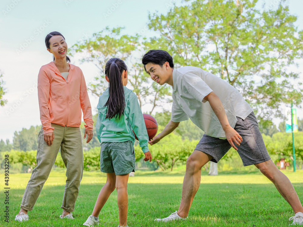Happy family of three playing basketball in the park Happy family of three playing basketball in the park