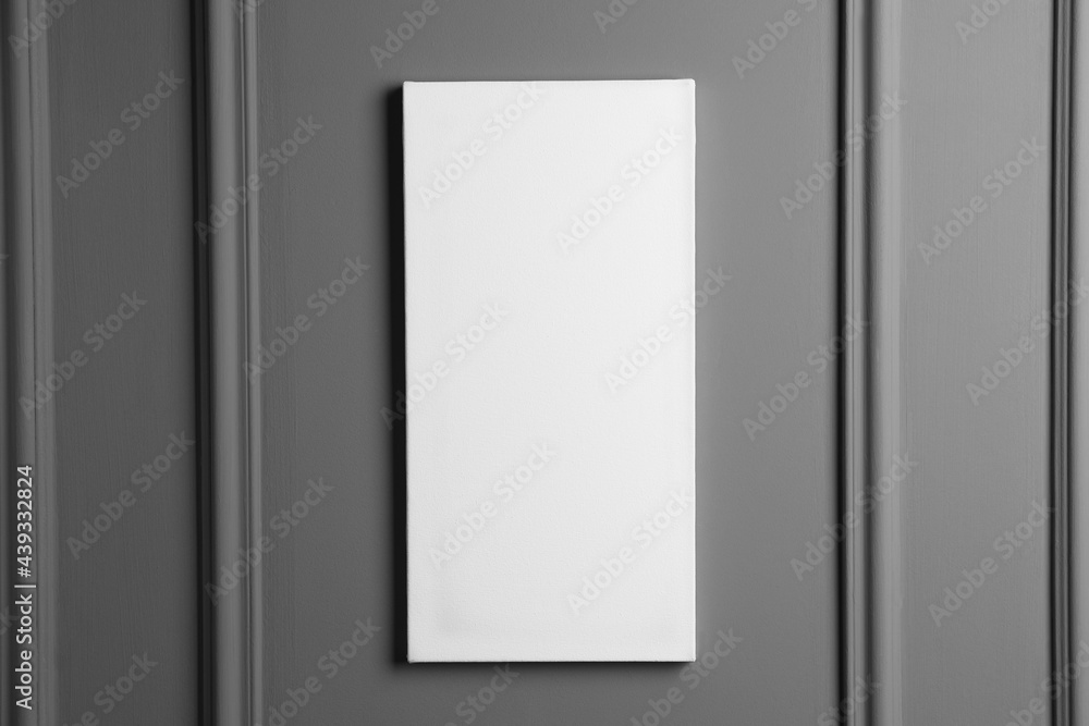 Blank canvas hanging on grey wall, space for text Blank canvas hanging on grey wall, space for text