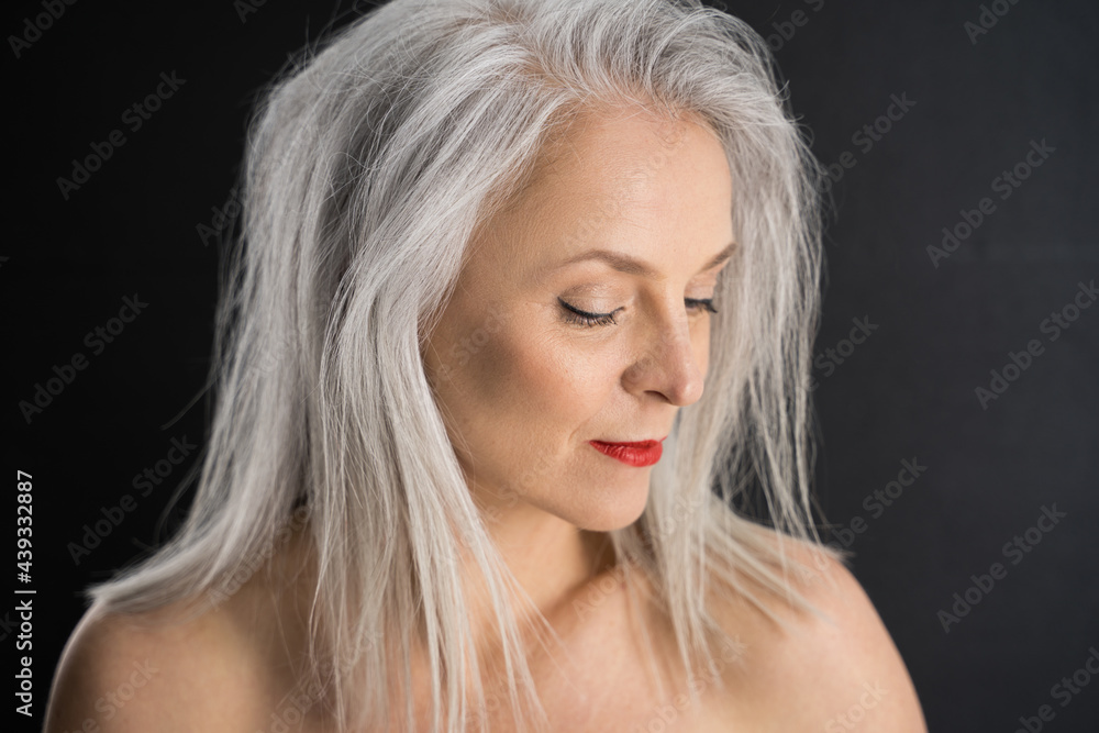 Mature woman with red lips looking down isolated on black background Mature woman with red lips looking down isolated on black background