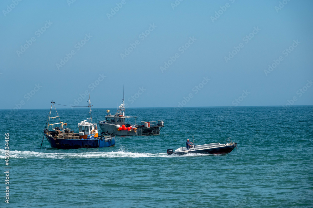 speed boat passing fishing trawlers in the sea
