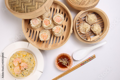 Prawn shrimp shaomai Xiao long bao dim sum dumpling chicken prawn fish seafood vegetable in bamboo steamer sauce chopsticks on white background