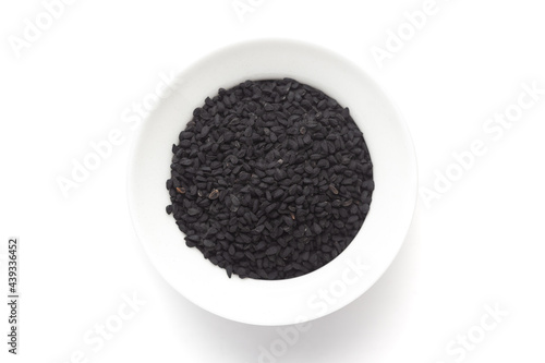 Macro close-up of Organic black cumin  (Nigella sativa) or kalonji on white background. Pile of Indian Aromatic Spice. Top view