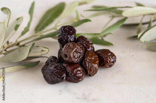 Close-up black olives. Organic olives on a marble floor