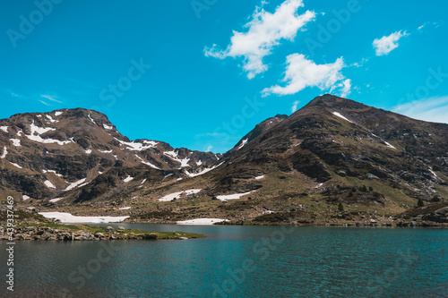Landscape with a blue lake between mountains with blue sky.