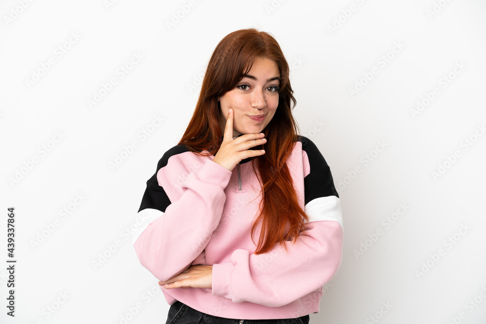 Young redhead woman isolated on white background and thinking