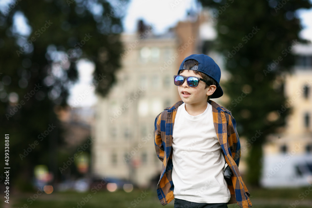 boy in town wearing sunglasses. Baby plays with soap bubbles