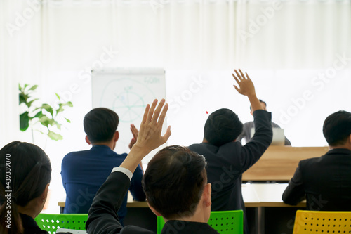 Businessman raising hand for asking speaker for question and answer concept in meeting room for seminar