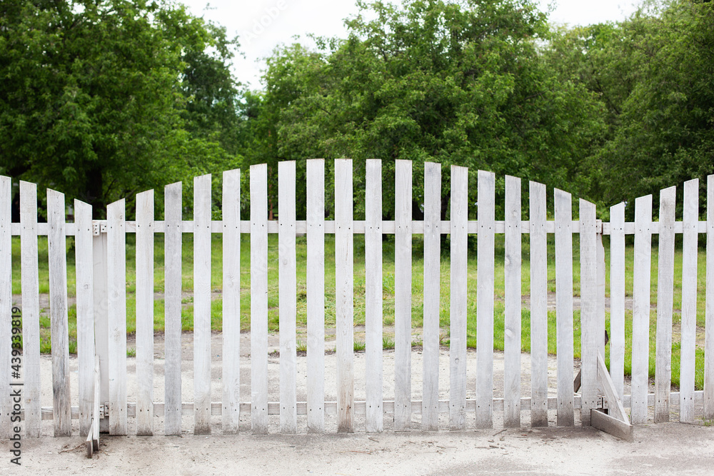 Summer garden in backyard and wooden fence. Wooden Fence Solid Privacy in rustic style. Long country style garden fence in countryside. White fence on green grass and the trees behind.
Summer garden in backyard and wooden fence. Wooden Fence Solid Privacy in rustic style. Long country style garden fence in countryside. White fence on green grass and the trees behind.
