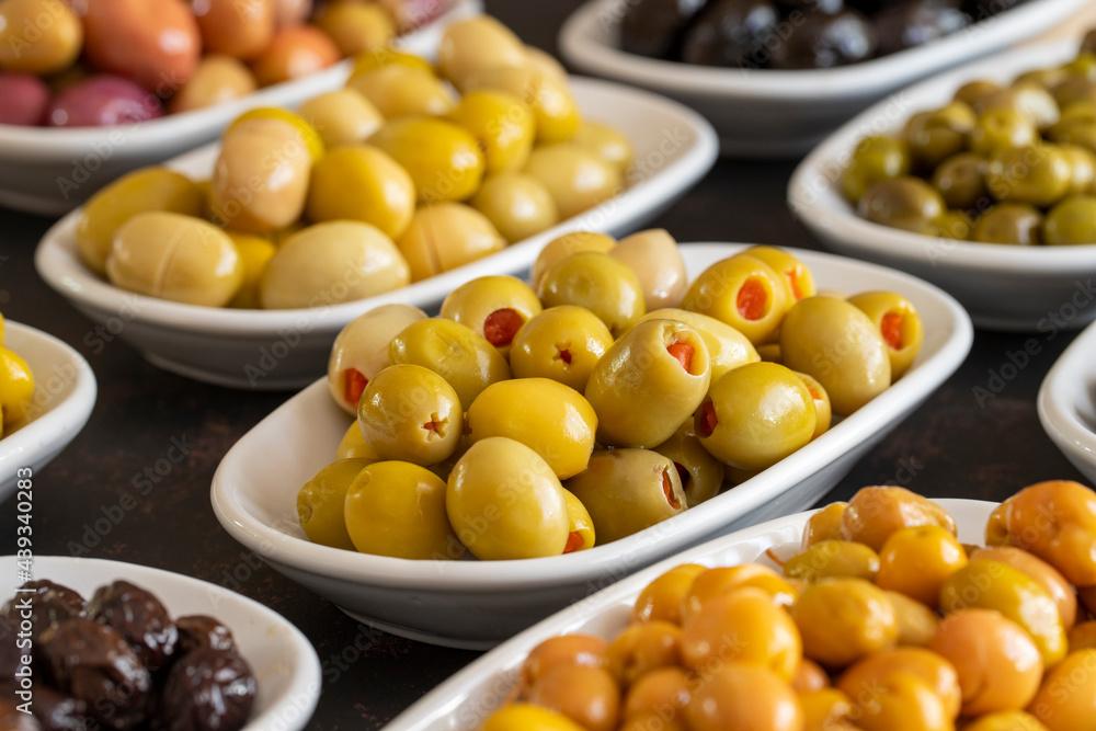 Assortment of olives on the plate in bulk. Organic black olives, Olive varieties Assortment of olives on the plate in bulk. Organic black olives, Olive varieties