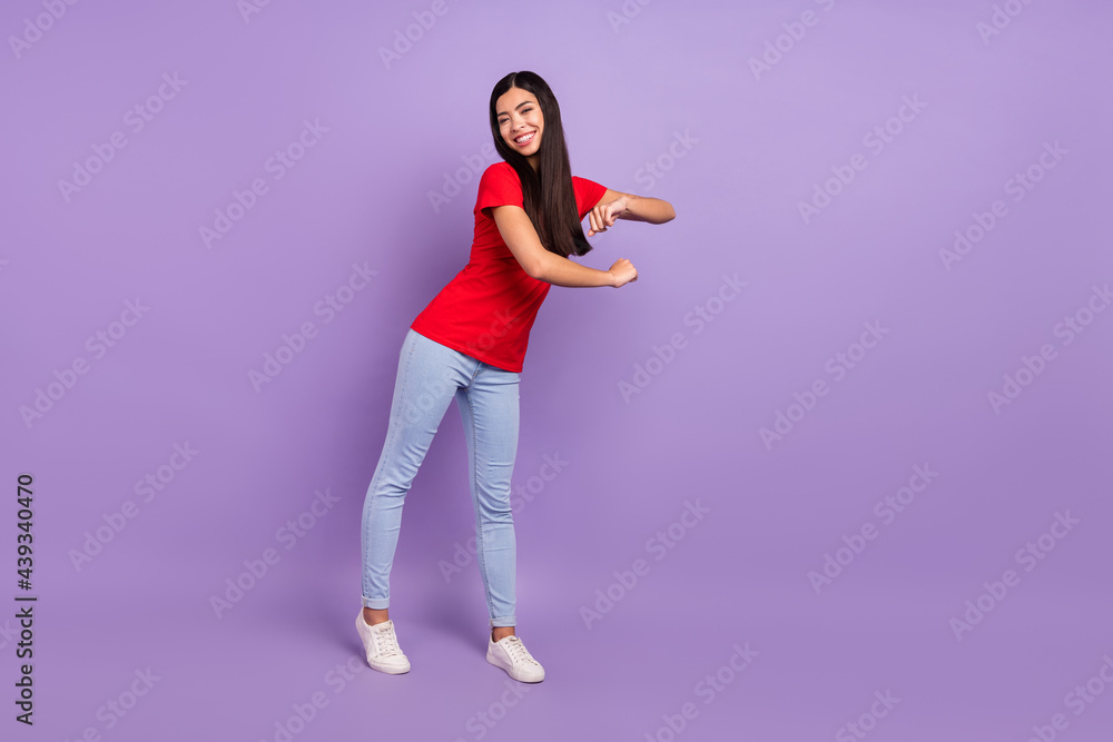 Full body photo of cute young brunette hairdo lady dance wear red t-shirt jeans isolated on violet color background Full body photo of cute young brunette hairdo lady dance wear red t-shirt jeans isolated on violet color background