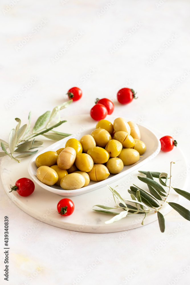 Yellow kalamata olives. Tasty organic yellow olives in the plate. Olive on marble floor Yellow kalamata olives. Tasty organic yellow olives in the plate. Olive on marble floor