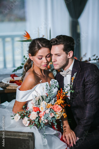 Close-up portraits of beautiful couple of newlyweds with bridal bouquet