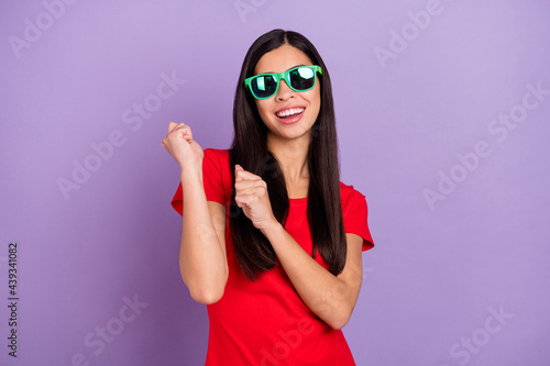 Photo of charming pretty young lady wear red outfit dark eyewear dancing smiling isolated violet color background