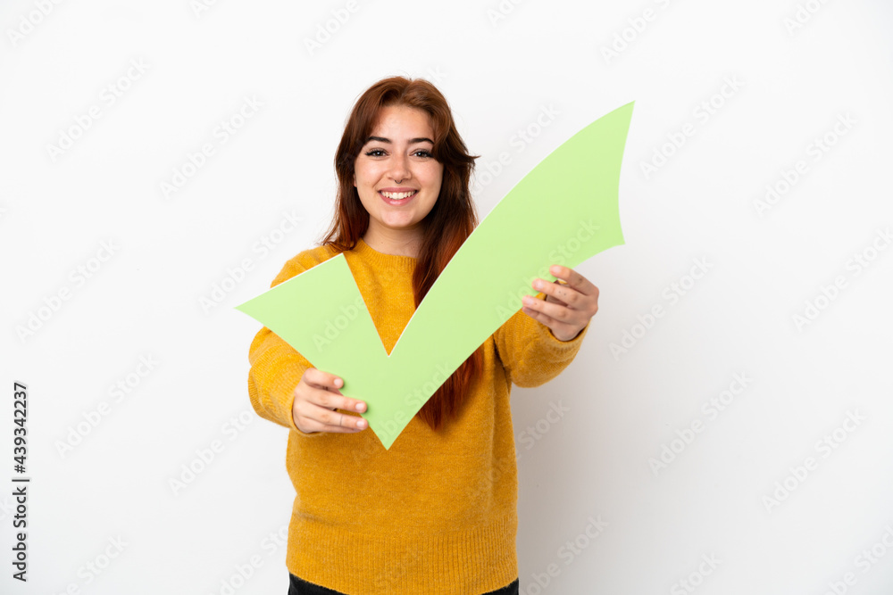 Young redhead woman isolated on white background holding a check icon with happy expression Young redhead woman isolated on white background holding a check icon with happy expression