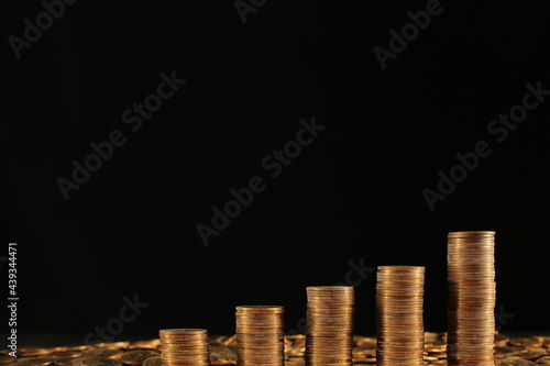 A large variety of coins isolated on a black background. Stack o