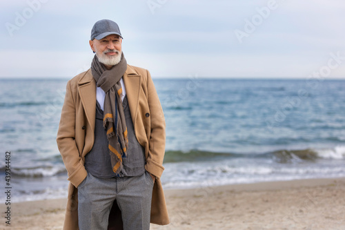 an aged man walking along the beach against the background of the sea © zokov_111