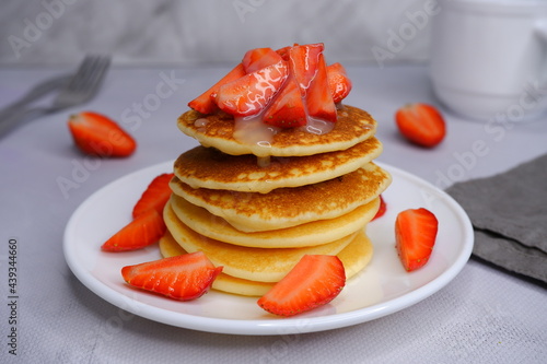 Pancakes with strawberries on a blurred background. Food photography.