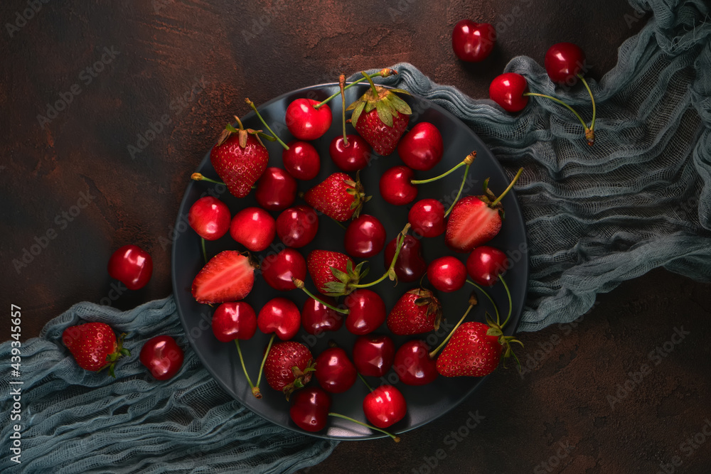 Fresh organic summer mix of strawberry and sweet cherry in round stone plate Fresh organic summer mix of strawberry and sweet cherry in round stone plate