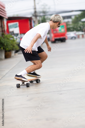 Asian young man playing surfskate or skate board in gas station urban city outdoor. Extream sports © NVB Stocker