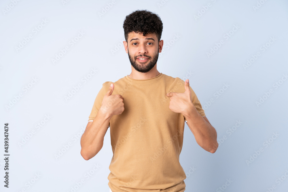 Fototapeta premium Young Moroccan man isolated on blue background with surprise facial expression
