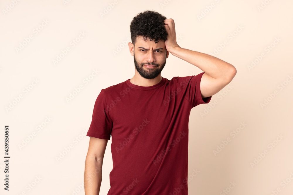 Young Moroccan man isolated on beige background with an expression of frustration and not understanding Young Moroccan man isolated on beige background with an expression of frustration and not understanding