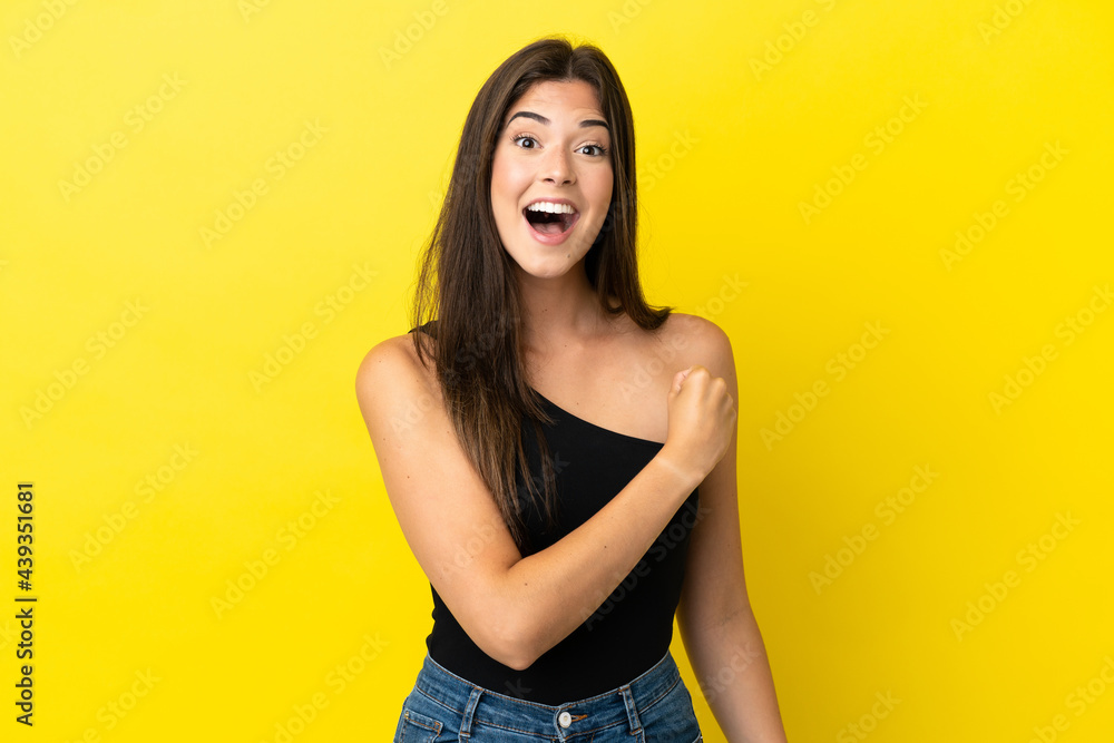 Young Brazilian woman isolated on yellow background celebrating a victory Young Brazilian woman isolated on yellow background celebrating a victory