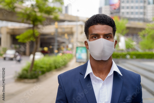 Portrait of African businessman wearing face mask outdoors
