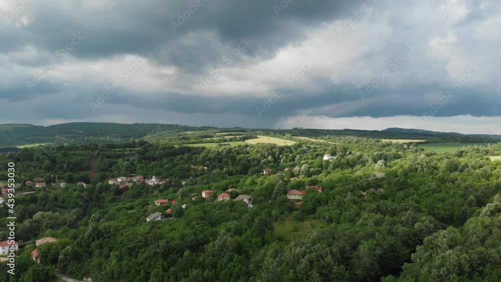 Flying by road and village hidden in the mountains before rain
