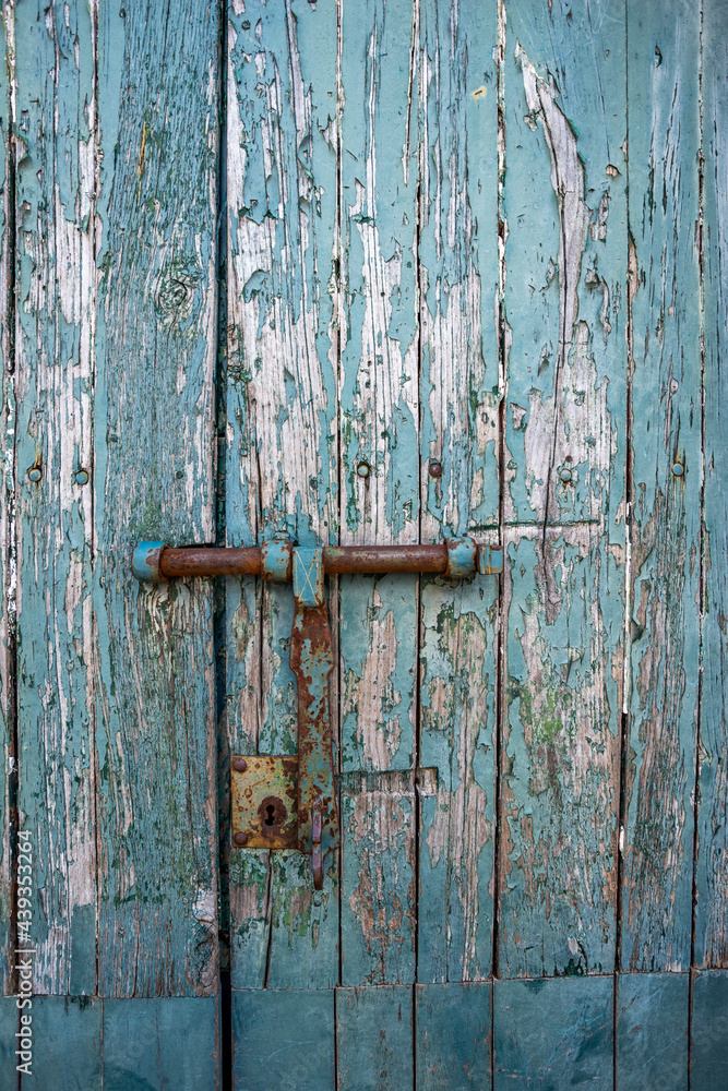 Old and rusty bolt and lock on exterior door with blue paint Old and rusty bolt and lock on exterior door with blue paint