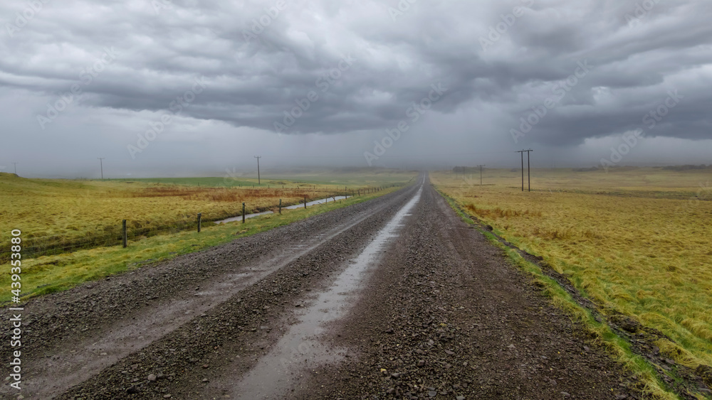 Gravel road in Iceland countryside with stormy weather