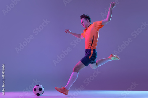 One male soccer football player in action and motion isolated on gradient lilac pink background in neon light © master1305