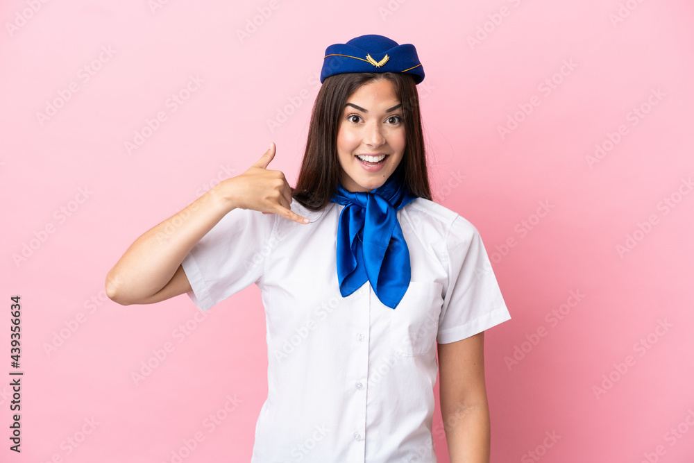 Airplane stewardess Brazilian woman isolated on pink background making phone gesture. Call me back sign