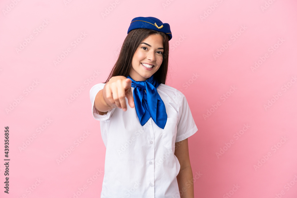 Airplane stewardess Brazilian woman isolated on pink background points finger at you with a confident expression Airplane stewardess Brazilian woman isolated on pink background points finger at you with a confident expression