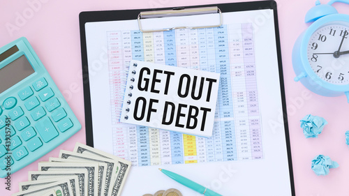 Paper note with text Get Out Of Debt on the office table