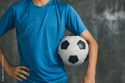 boy wearing blue shirt holding a classic football © Treecha