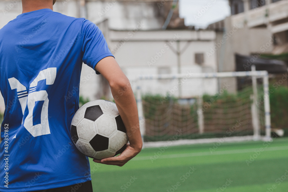 Fototapeta premium boy wearing blue shirt holding a classic football