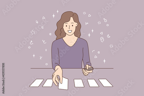 Playing cards and individual prognosis concept. Beautiful smiling young woman cartoon character sitting laying out cards on table over grey background vector illustration 