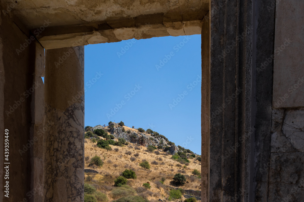 View of Aegean landscape through a historical window captured in famous ancient Greek city called 