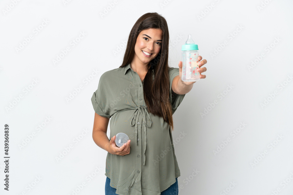 Young Brazilian woman isolated on white background pregnant and holding a feeding bottle Young Brazilian woman isolated on white background pregnant and holding a feeding bottle
