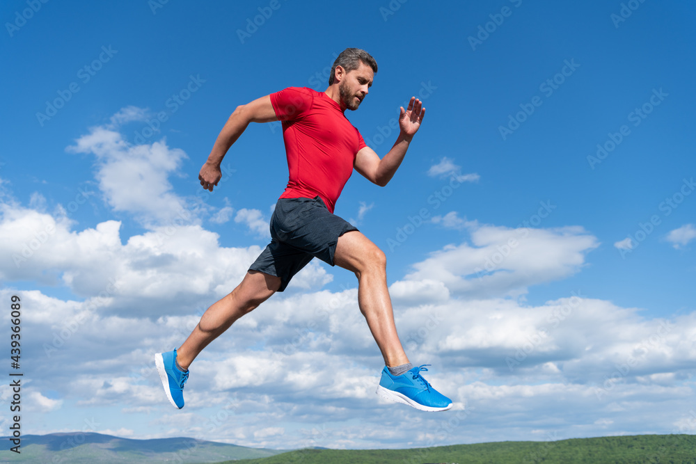 sportsman man runner run to success or jump high on sky background, sport