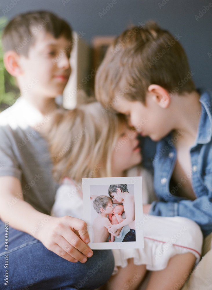 siblings hold old printed photograph when they were younger siblings hold old printed photograph when they were younger